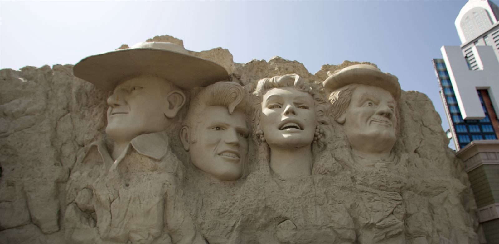 Giant sculpted faces of John Wayne, Elvis Presley, Marilyn Monroe and Charlie Chaplin on a wax museum facade in Branson
